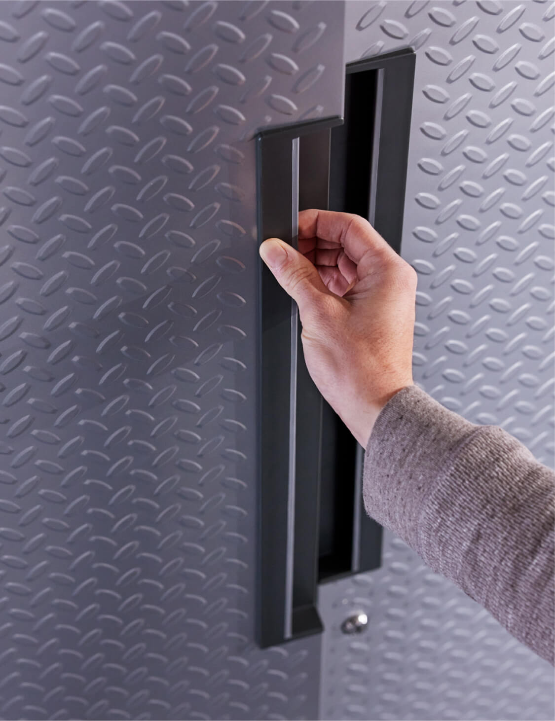 A hand opening a Gladiator® cabinet.