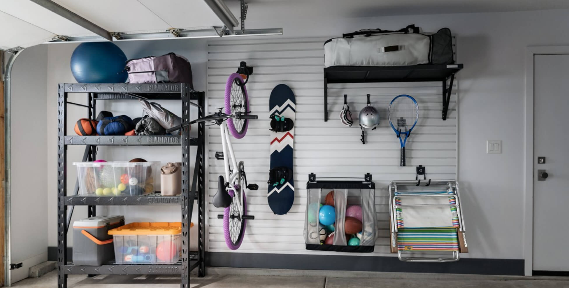 Various sports equipment and other items hanging on a Gladiator® GearWall® Panel