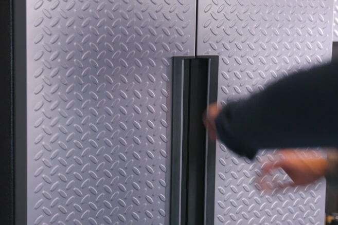 A hand opening a Gladiator® cabinet.