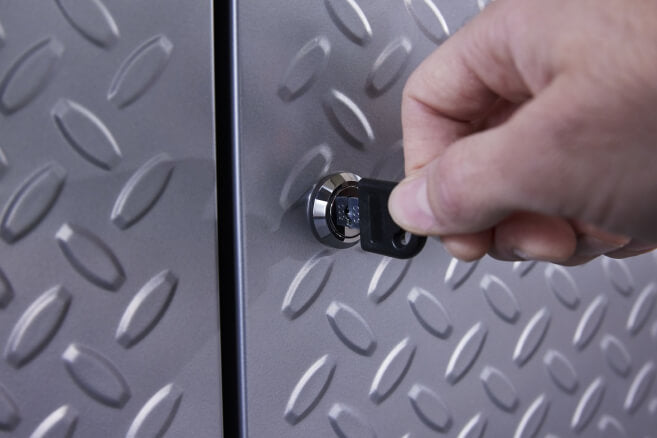 A hand locking a Gladiator® cabinet.